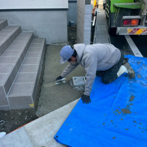 滋賀県大津市の新築外構現場。アプローチの石貼りの土台となるコンクリート下地を丁寧に施工している様子。