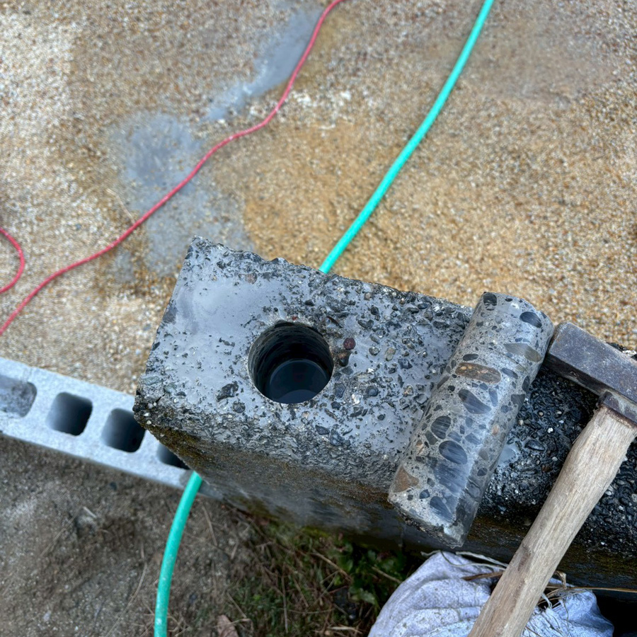 賀県大津市の新築外構現場にて、既存の擁壁にフェンス用の穴をあけるコア抜き（ホルス）加工の様子。