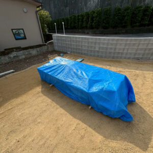 滋賀県大津市の新築外構現場にて、到着した外構資材をブルーシートで丁寧に養生して保管している様子。