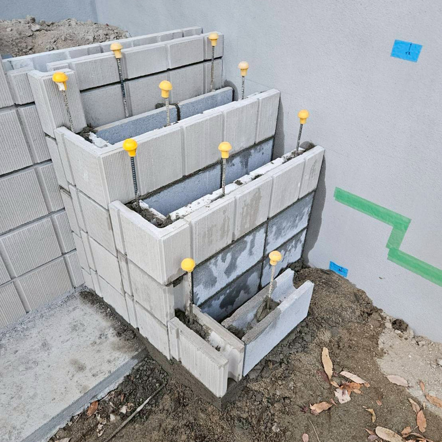 滋賀県大津市の新築外構現場にて、階段の下地となるコンクリートブロックを正確に積み上げている施工風景。