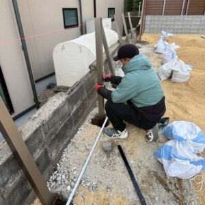 滋賀県大津市の新築外構工事にて、アーバンフェンスの支柱を垂直に固定する様子。