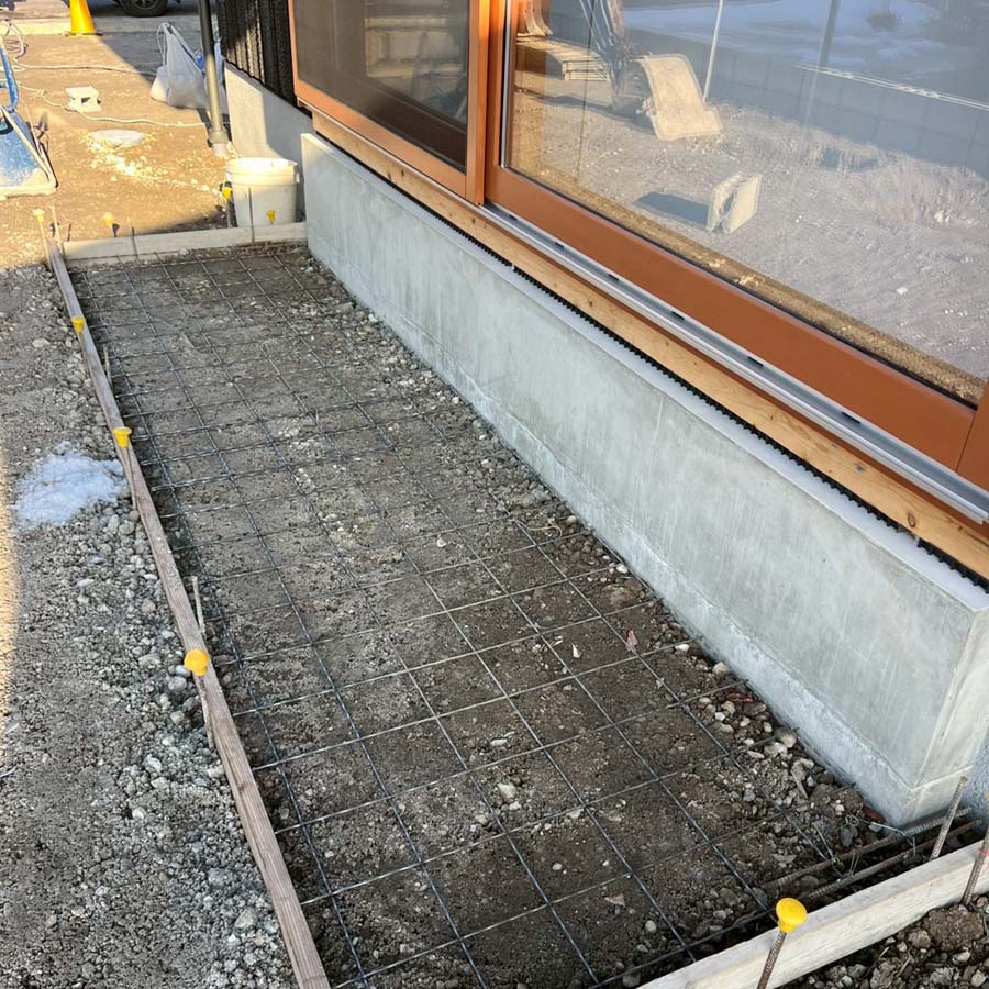 滋賀県豊郷町の新築外構現場にて、ウッドデッキの下をコンクリートで仕上げるために型枠を組み、ワイヤーメッシュを配置している様子。