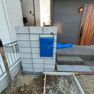 滋賀県近江八幡市の新築外構現場にてブロックを積み上げポストを仮設置した門柱の施工風景。