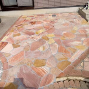滋賀県草津市のリフォーム外構現場にて、アプローチ横の乱形石貼りが目地詰めと拭き取りを終えて完成した様子。
