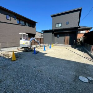 滋賀県草津市の旗竿地にある新築現場にて重機を配置し外構の土工事を行っている様子。