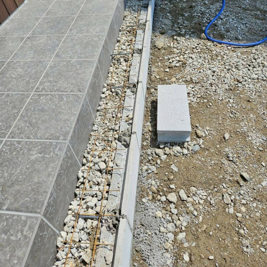 滋賀県草津市の新築外構現場にて玄関アプローチの階段をつくるためにブロックを積み配筋と砕石敷きを行っている様子。