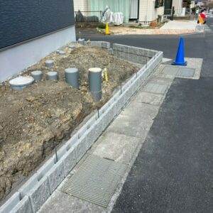 滋賀県草津市の新築外構現場にて敷地の境界線に化粧ブロックを綺麗に積み上げている様子。
