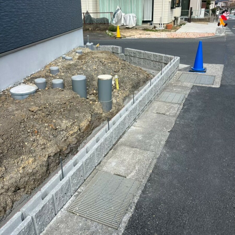 滋賀県草津市の新築外構現場にて敷地の境界線に化粧ブロックを綺麗に積み上げている様子。