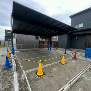 滋賀県草津市の新築外構現場にてYKKapのカームブラック仕様カーポート「エフルージュFIRST EX」と土間コンクリート養生の様子。