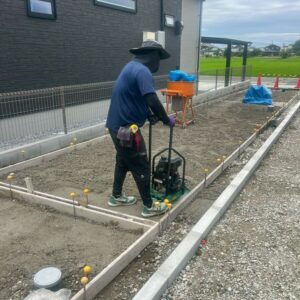 滋賀県草津市の新築旗竿地現場にて土間コンクリート施工のために型枠を組み転圧機で下地を固めている様子。