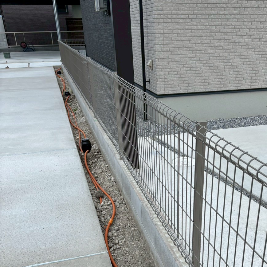 滋賀県草津市の新築旗竿地現場にて通路沿いにタカショーの照明オルテックS(HBD-D41S・12V)を設置・配線している様子。