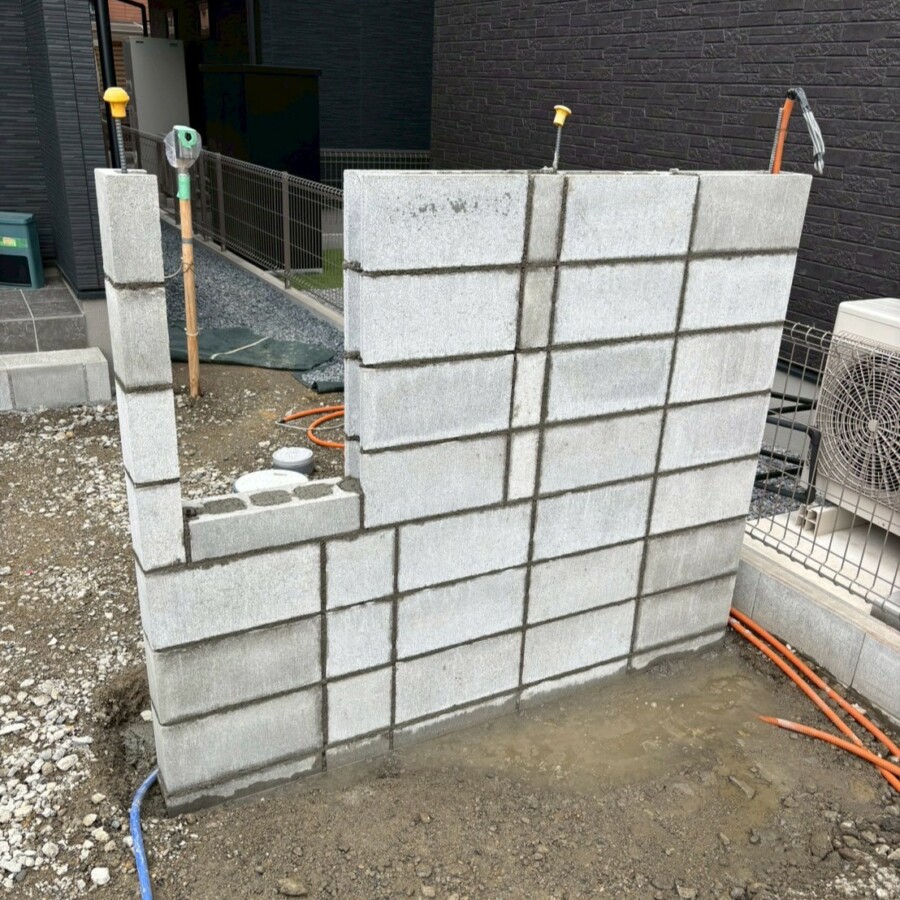 滋賀県草津市の新築外構現場にて宅配ボックスを埋め込むための造作門柱のブロック積み工事を行っている様子。