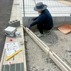 滋賀県近江八幡市の新築外構現場にて洗い出し仕上げと乱形石のアプローチをつくるために職人が型枠を設置している様子。