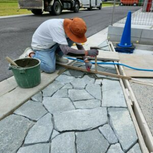 滋賀県近江八幡市の新築外構現場にて東洋石創の乱形石ルセルナクォーツのグレイミックスをアプローチに施工している様子。