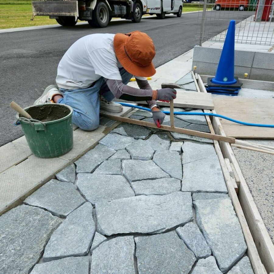 滋賀県近江八幡市の新築外構現場にて東洋石創の乱形石ルセルナクォーツのグレイミックスをアプローチに施工している様子。