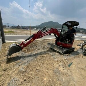 滋賀県湖南市の新築外構現場にて重機（ユンボ）を操作し着工・掘削作業を行う施工風景。