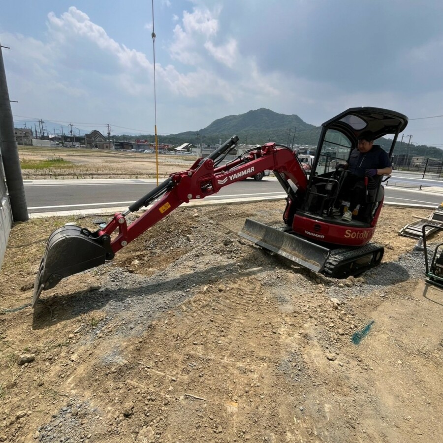 滋賀県湖南市の新築外構現場にて重機(ユンボ)を操作し着工・掘削作業を行う施工風景。