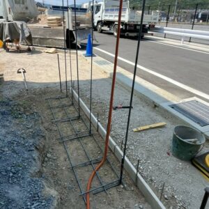 滋賀県湖南市の新築外構現場にて造作門柱の基礎鉄筋組みと配管を行う施工風景。
