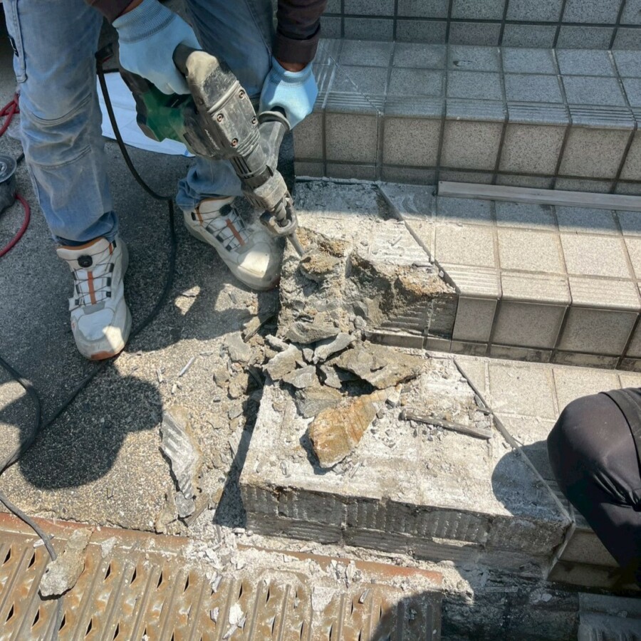 滋賀県草津市のリフォーム外構現場にて駐車場側の玄関階段の一部をハツリ解体する施工風景。