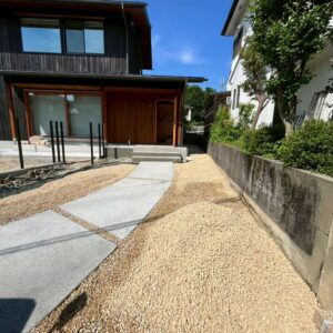 滋賀県草津市の新築外構現場にて完成したコンクリート洗い出し仕上げの玄関アプローチと周囲の砂利敷き。