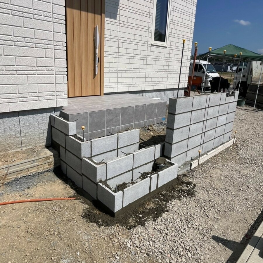 滋賀県湖南市の新築外構現場にて門柱と玄関アプローチステップの下地ブロックを積む施工風景。