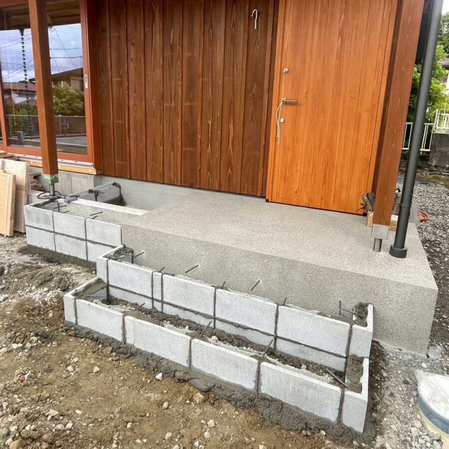 滋賀県草津市の新築外構現場にて玄関ポーチ前にステップ用のコンクリートブロックを積み鉄筋を配筋する様子。