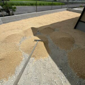 滋賀県草津市の新築外構現場にてお庭の人工芝敷き込みに向けて山砂を敷き均す下地整地風景。