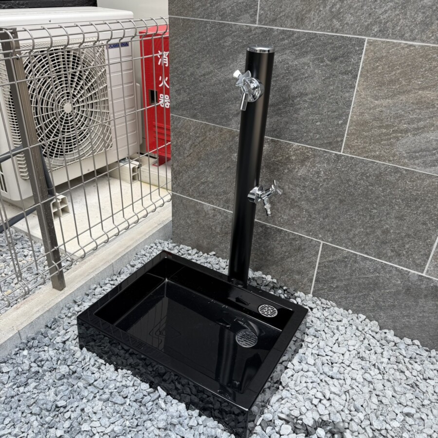 滋賀県草津市の新築外構現場に設置された前澤化成工業の立水栓メルス(ブラック・2口)とスクエアパン。