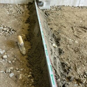 滋賀県栗東市の新築外構現場にて土間コンクリートのひび割れを防ぐ伸縮目地エキスパンタイをモルタルで固定する施工風景。