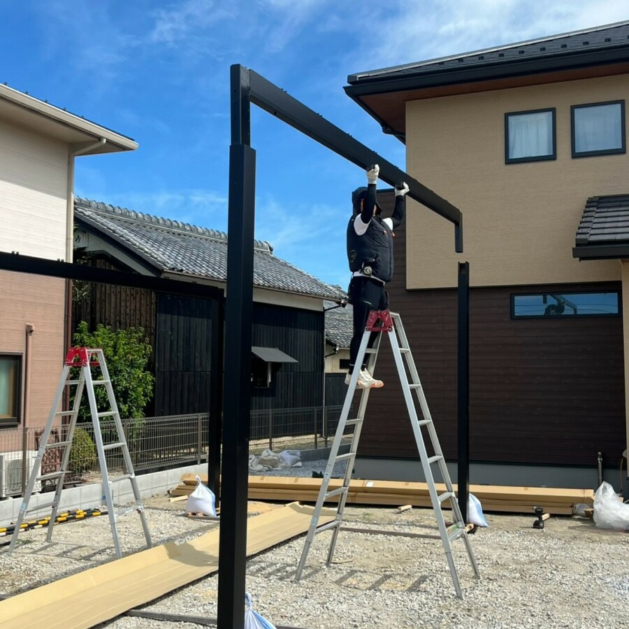 滋賀県草津市の新築外構現場にてYKK APのカーポート「エフルージュ FIRST」の梁と柱を組み立てる施工風景。