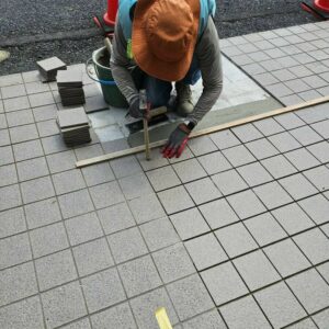 医療施設にて既存タイルに合わせて1枚ずつ高さを微調整しながらタイルの張り替え修復作業を行う職人。