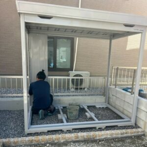 滋賀県湖南市の新築外構現場にてイナバ物置FORTA（FS-2214S）の骨組み・パネル組み立てを行う職人。
